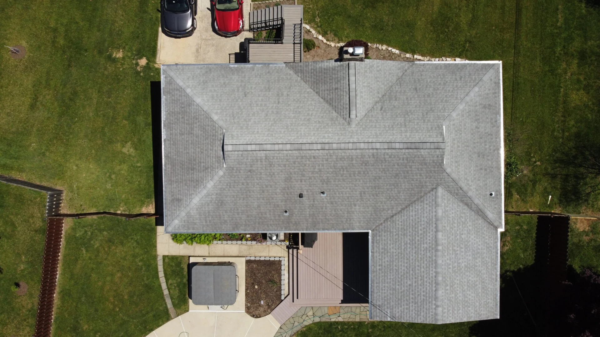 Aerial view of carpots with hard wood gray deck and wide range of lawn