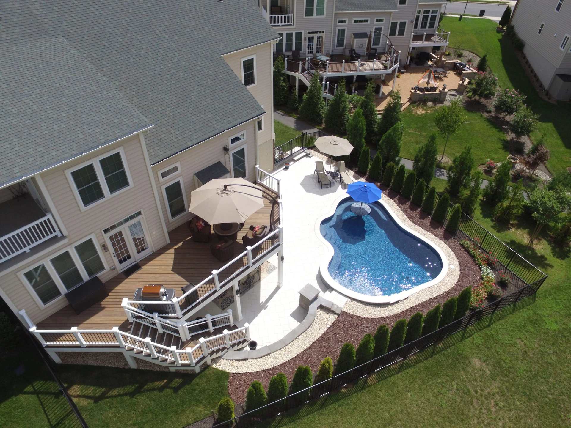 Aerial view of commercial deck with a pool and metal fence