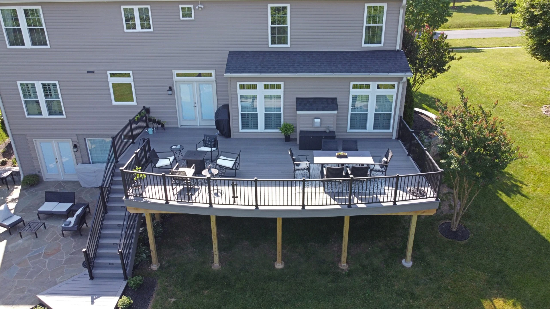 Aerial view of the elevated residential deck with metal railing and outdoor living furniture