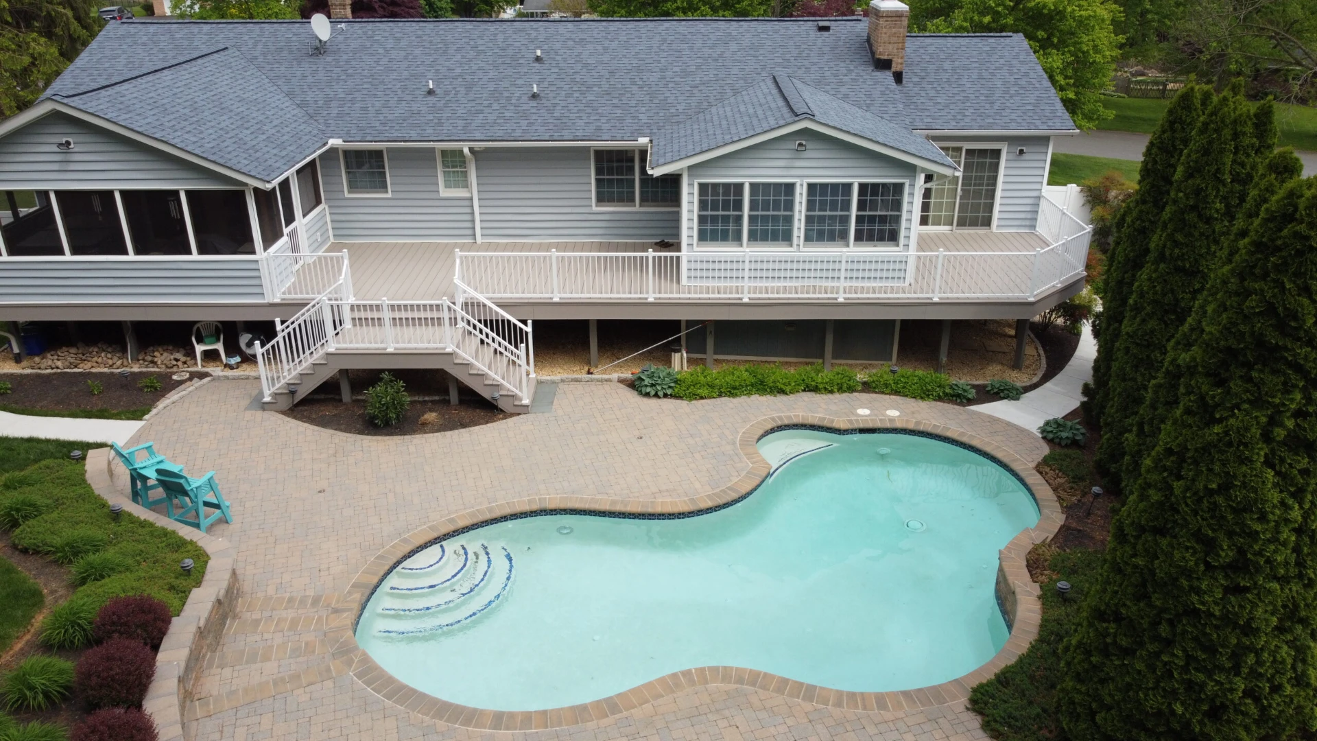 Aerial view of the raised deck with white railing and two porch featuring pool with overlooking view