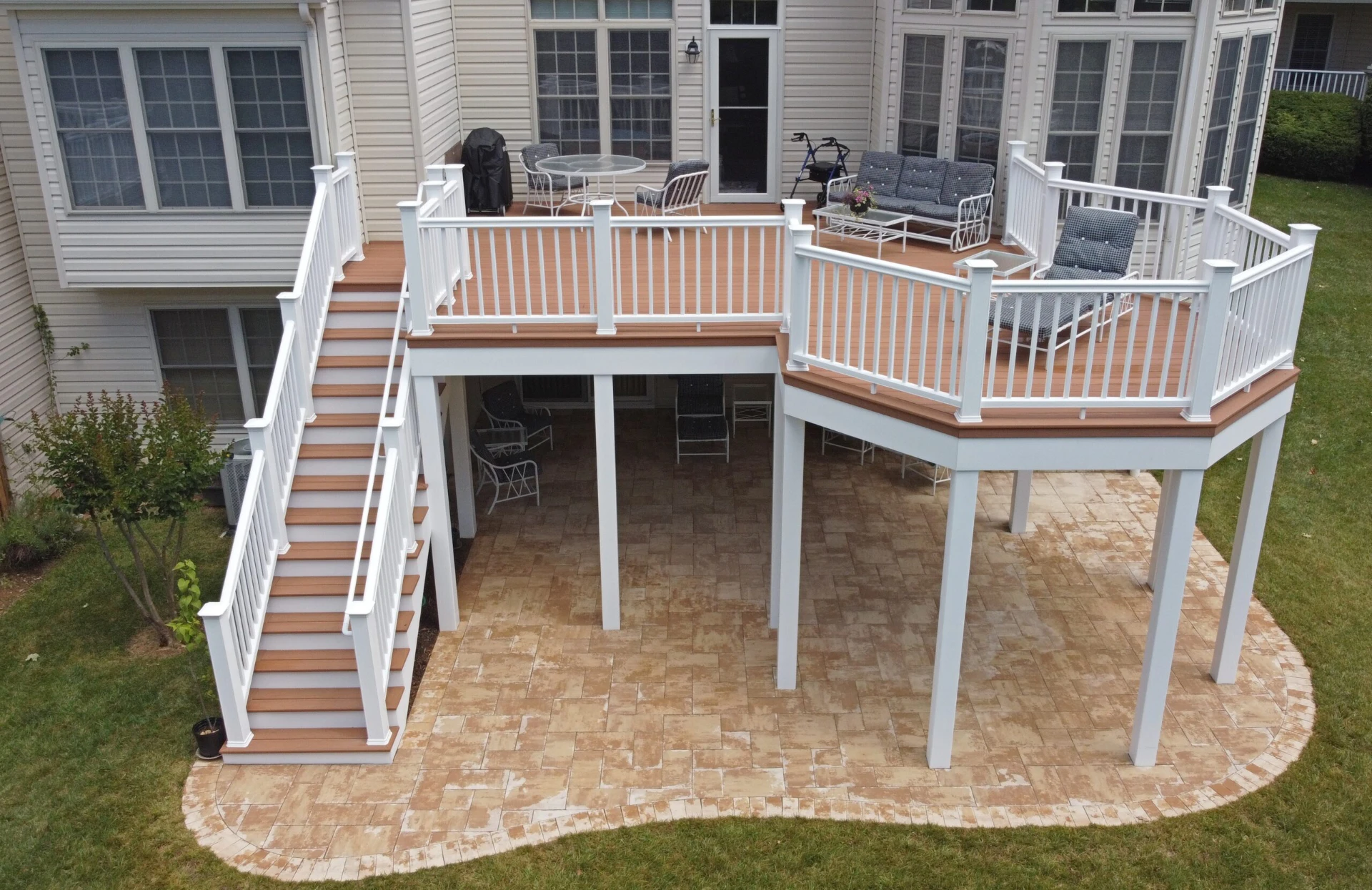 Elevated composite deck with white railing and outdoor living furniture