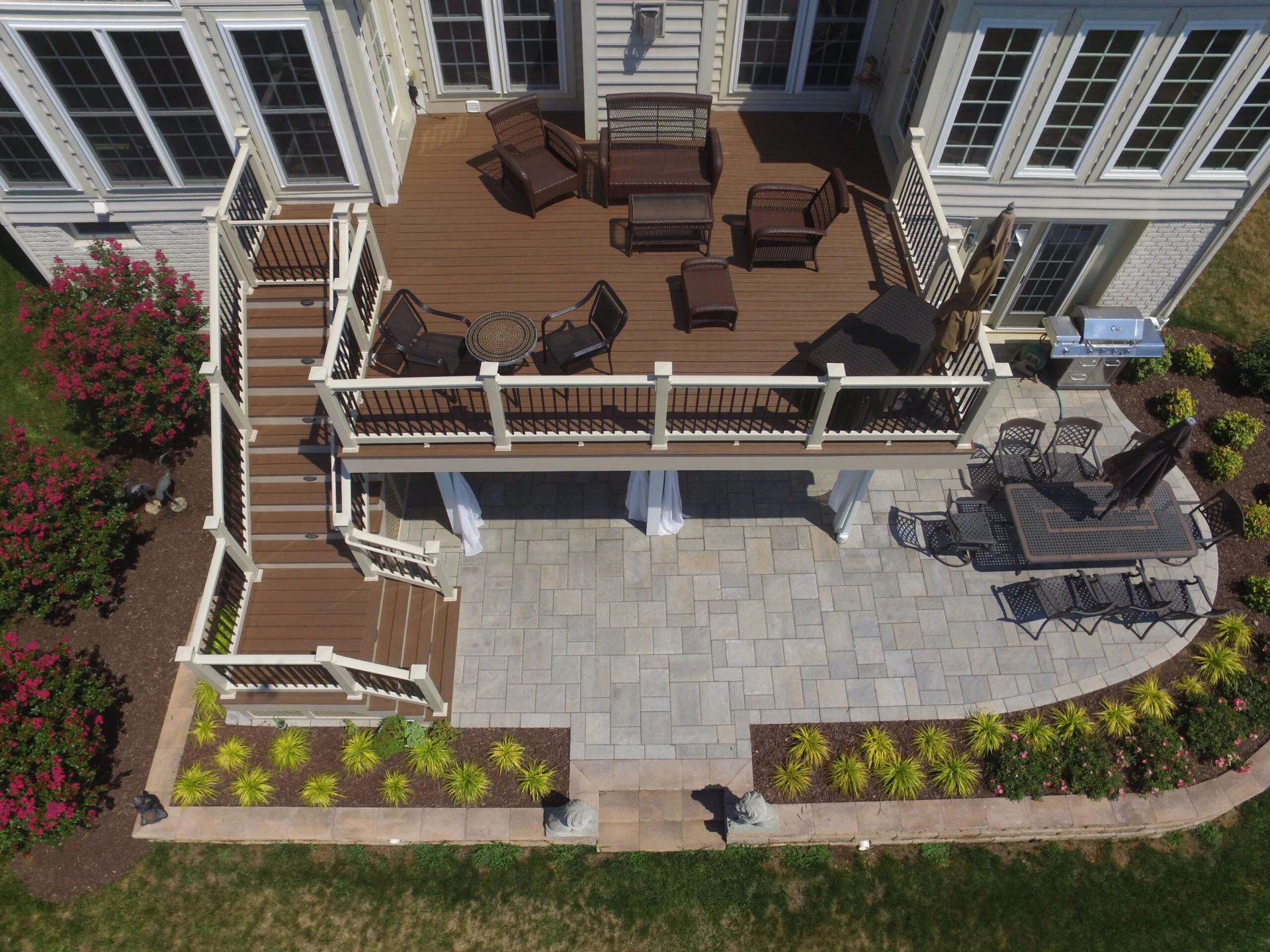Elevated composite wood deck with outdoor living furniture and outdoor living kitchen on the below on the deck