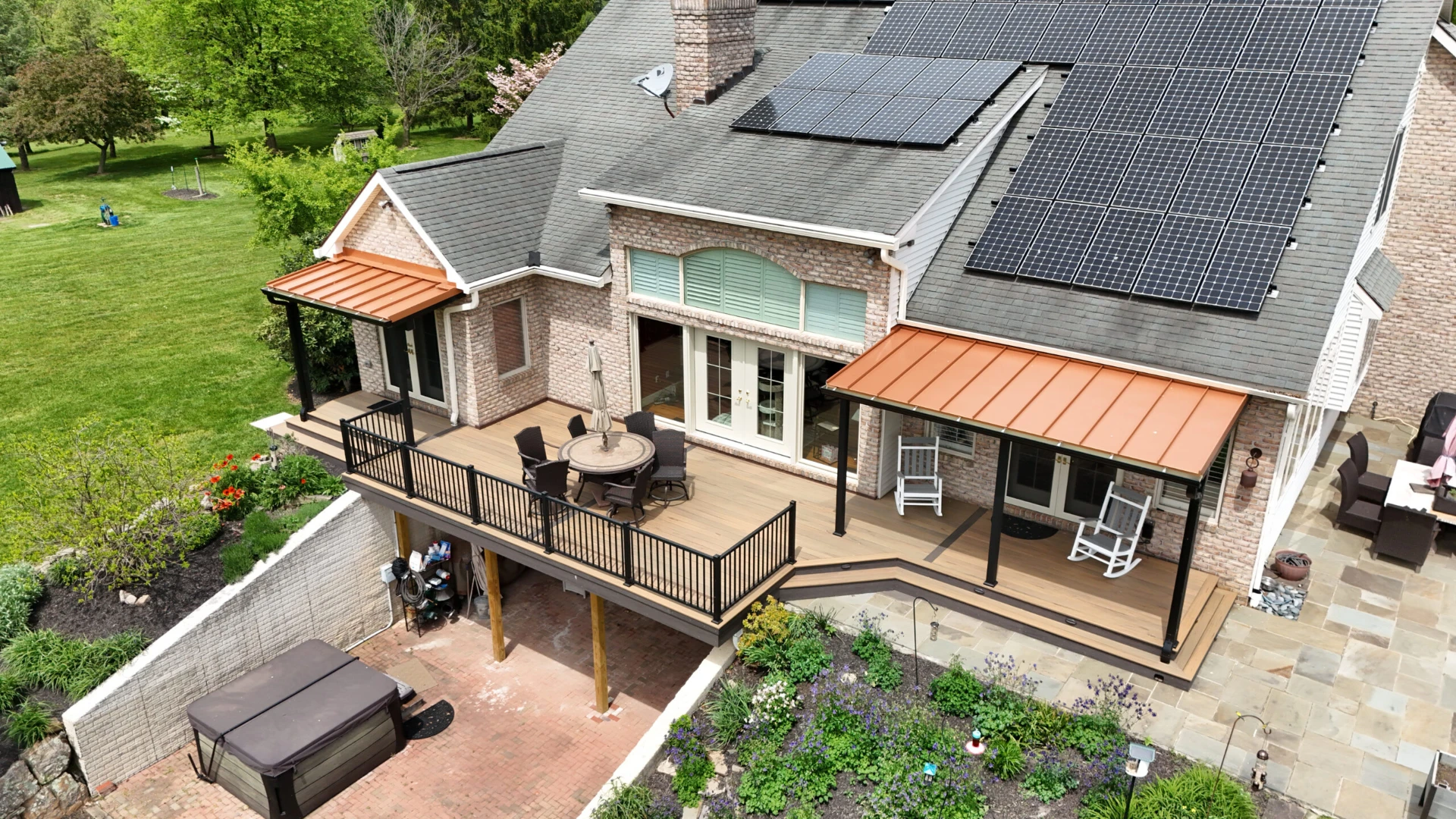 Elevated deck installation with black railing and furniture on the big house