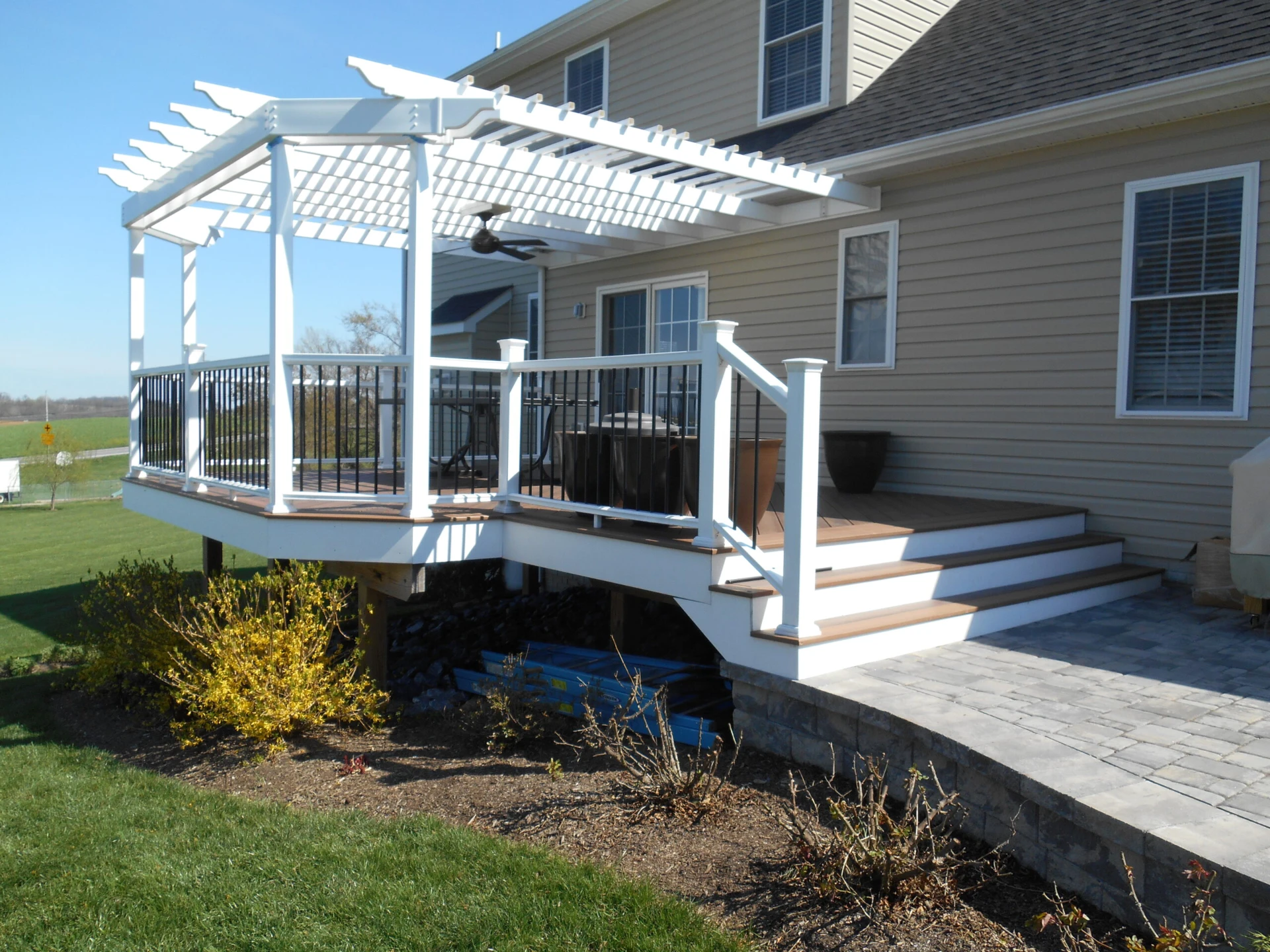 Elevated deck with white pergola and railing