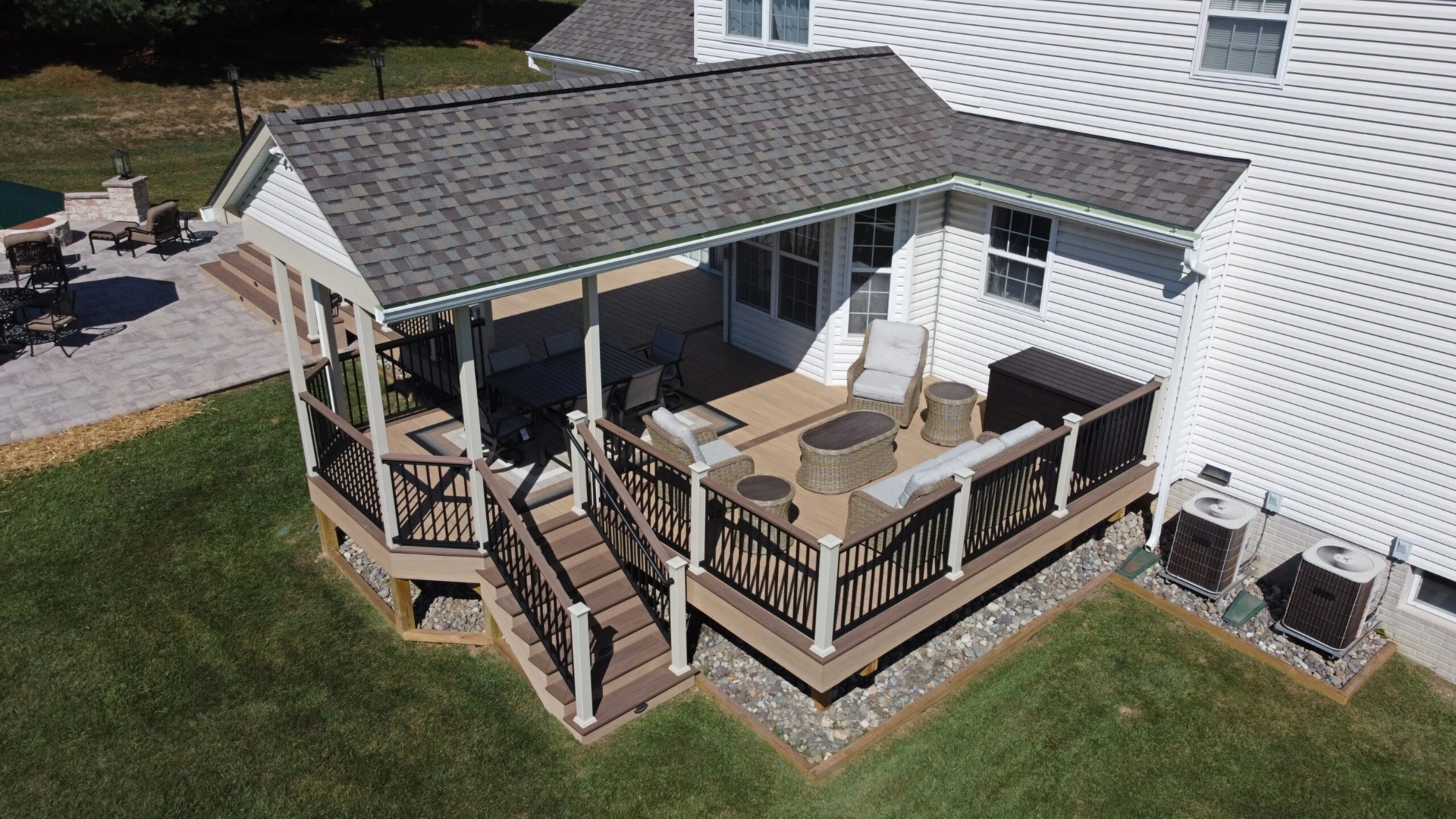 Elevated residential deck with custom porch with paver patio