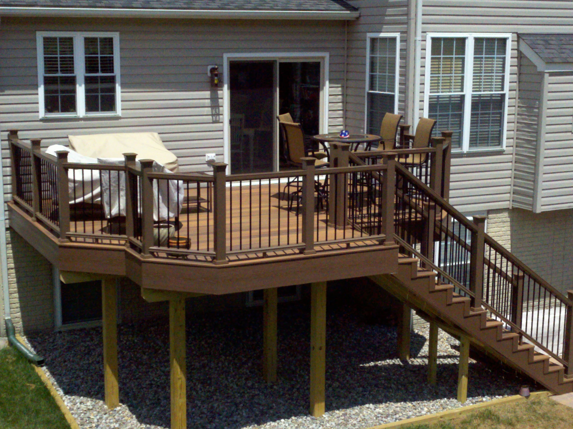 Elevated wooden deck with bronze deck railing and outside living furniture