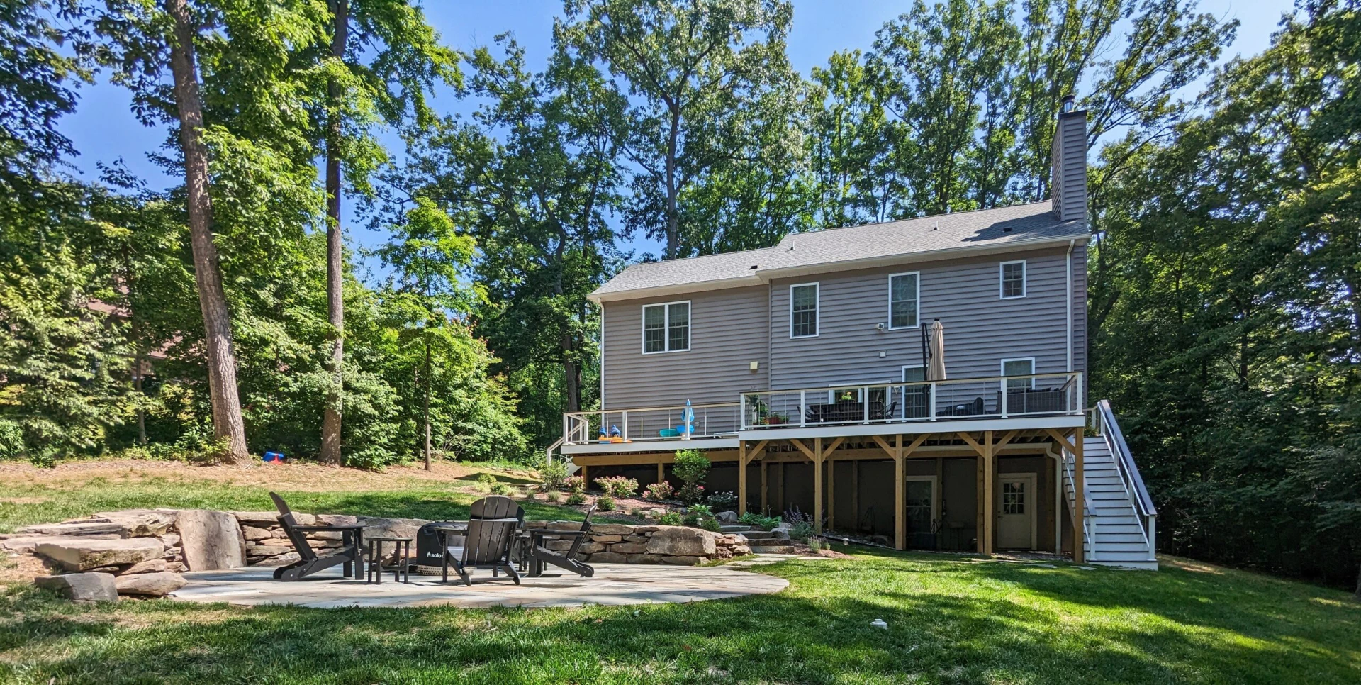 Flagstone patio with elevated deck with white deck railing