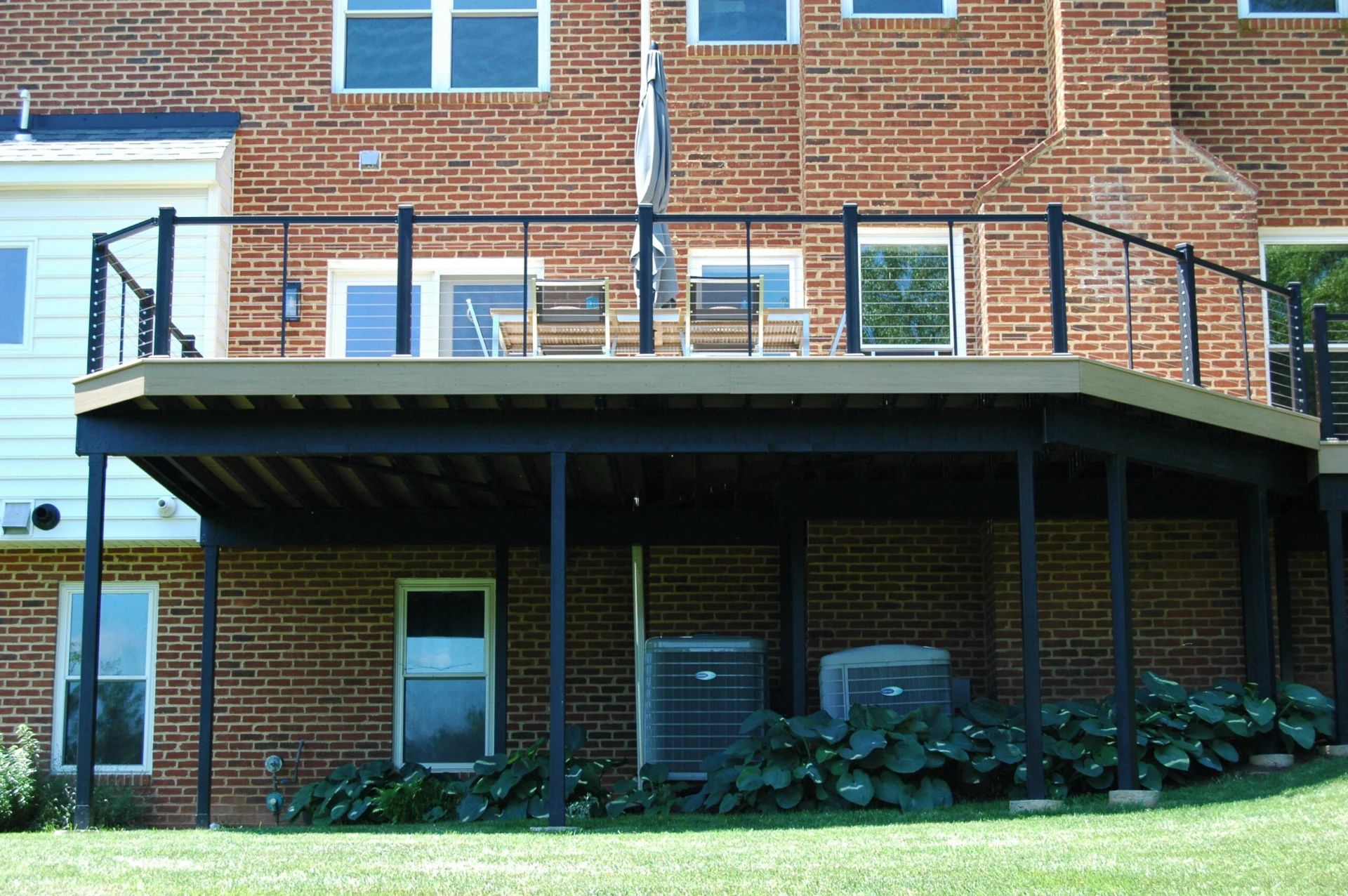Front view of the elevated deck with glass railing and outdoor furniture