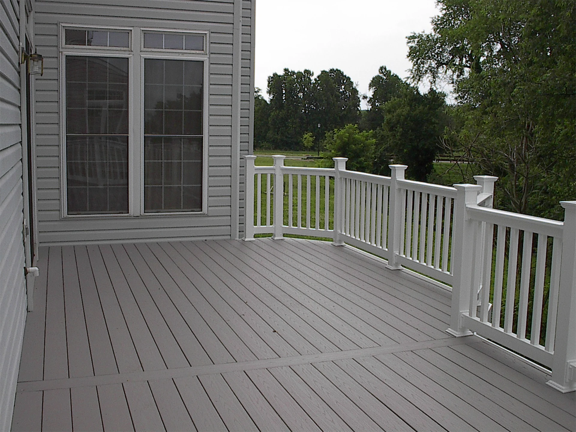 Gray deck with white railing and overlooking nature view