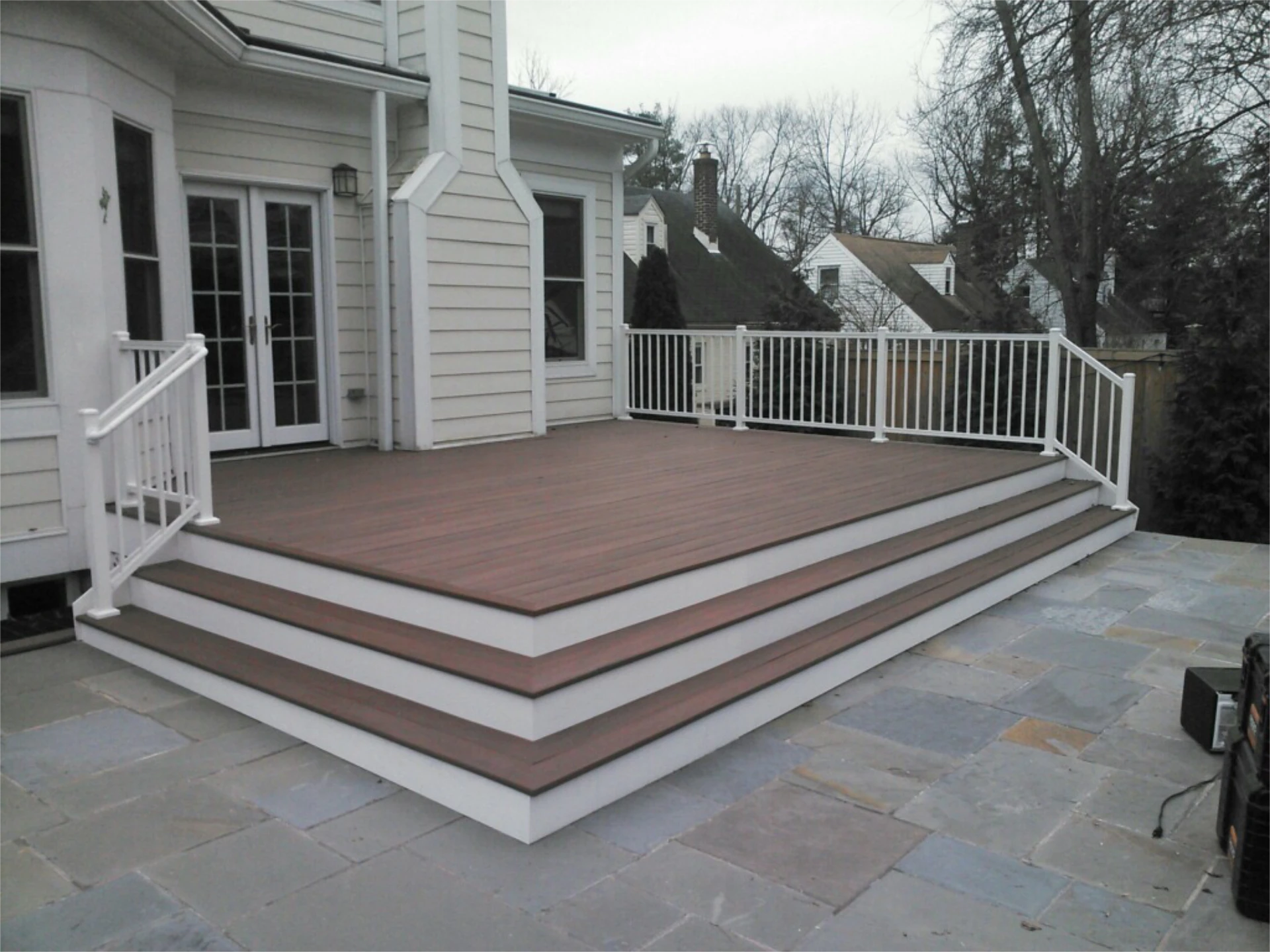 Hard wood deck with white railing on a cloudy area