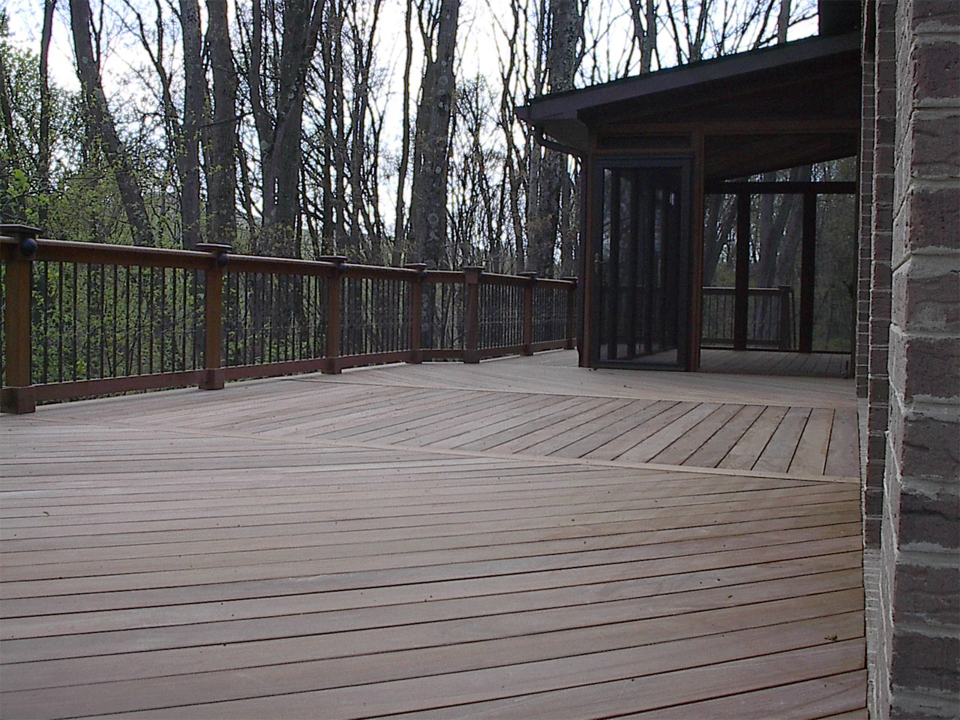 Hard wood deck with wooden railing and a custom made screened porch