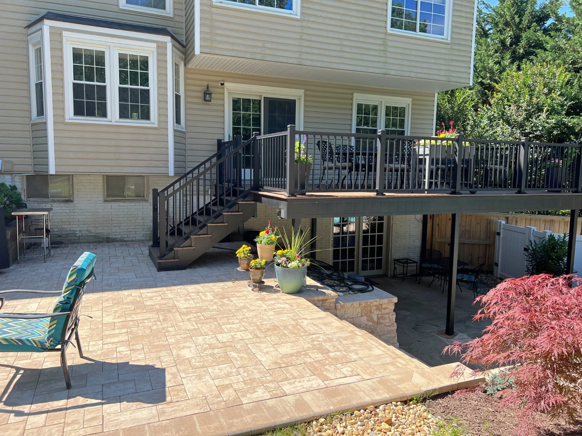 Raised deck with black railing and wooden fence on the bottom