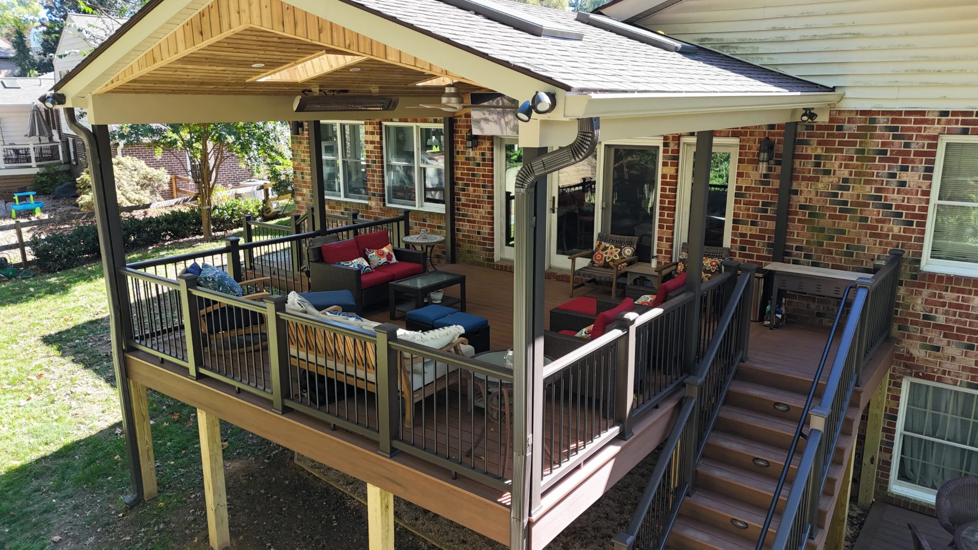 Raised hard deck with black railing and lighting and furniture