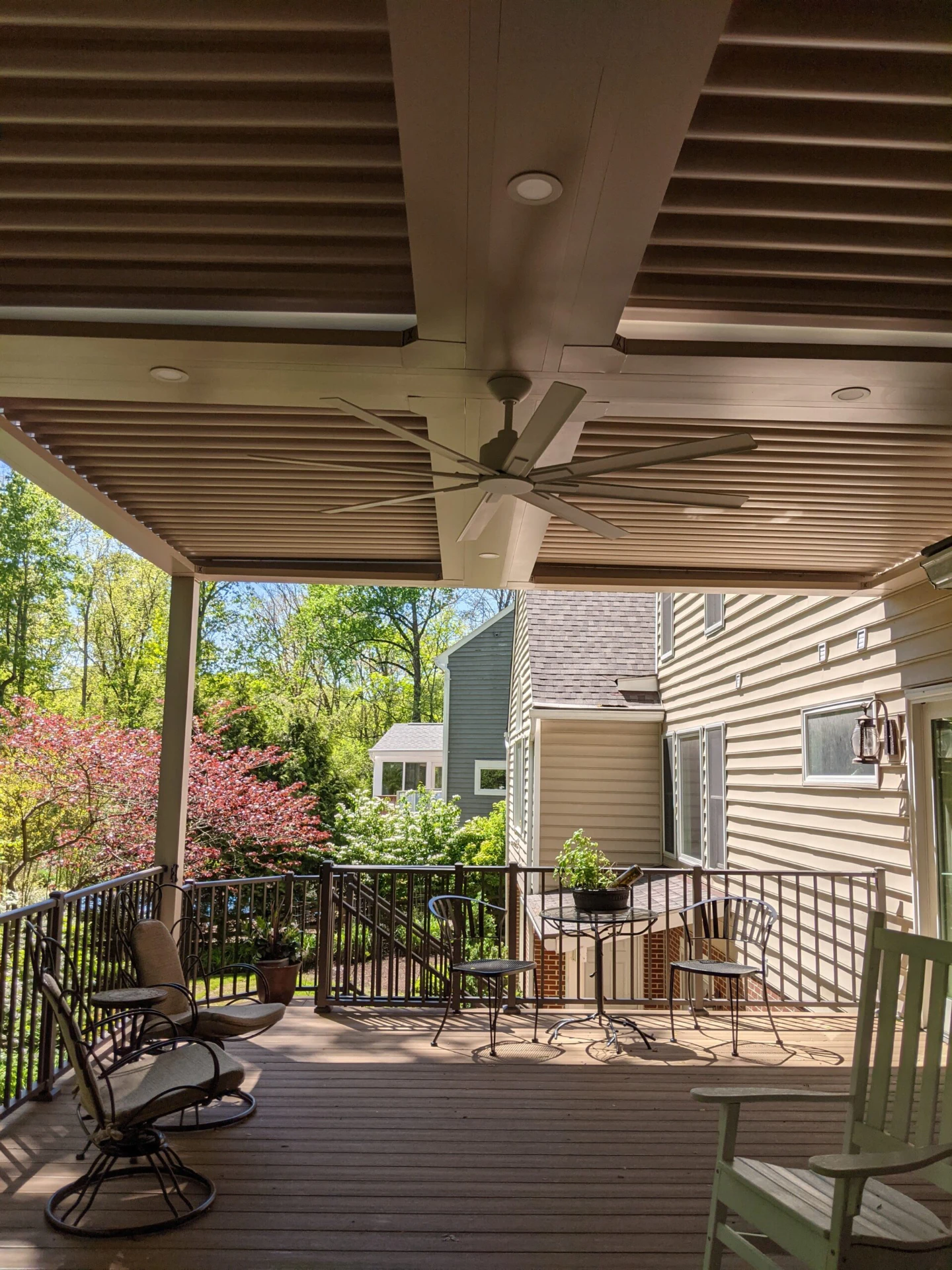 Residential decking with furniture and metal railing with forest view