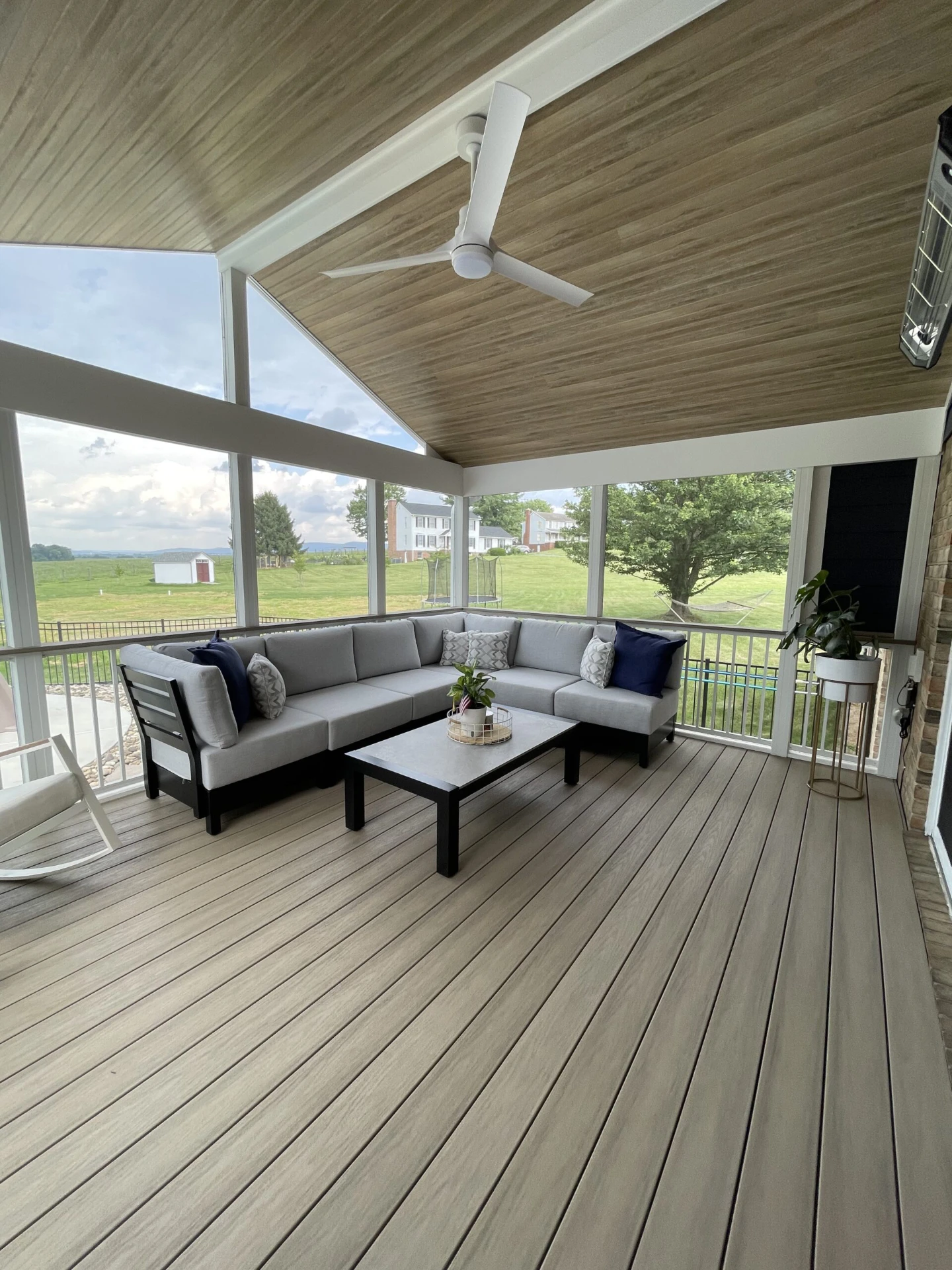 Screened porch installation with furniture and overlooking view outside