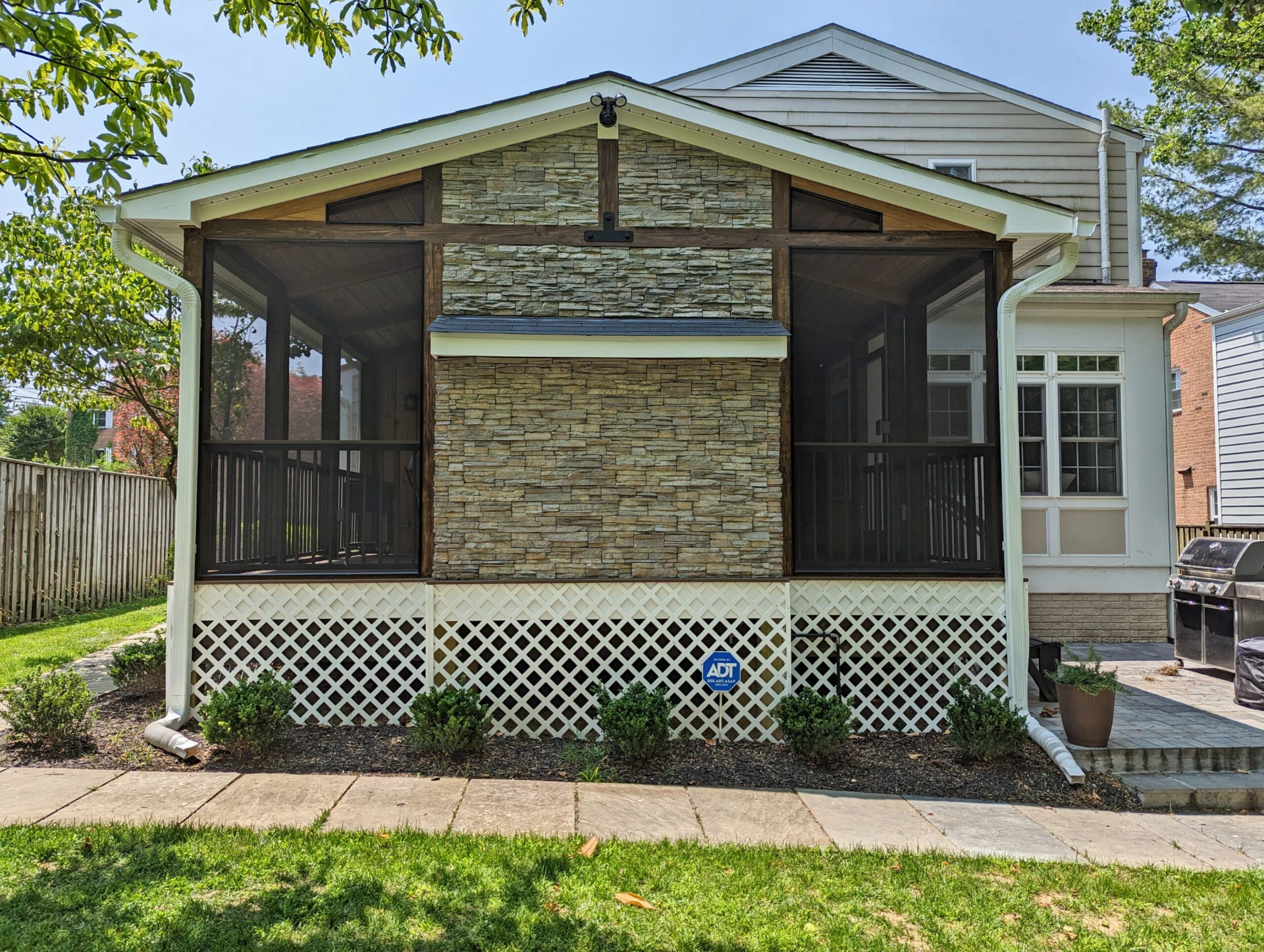 Screened porch with stacked stone fireplace and deck skirting