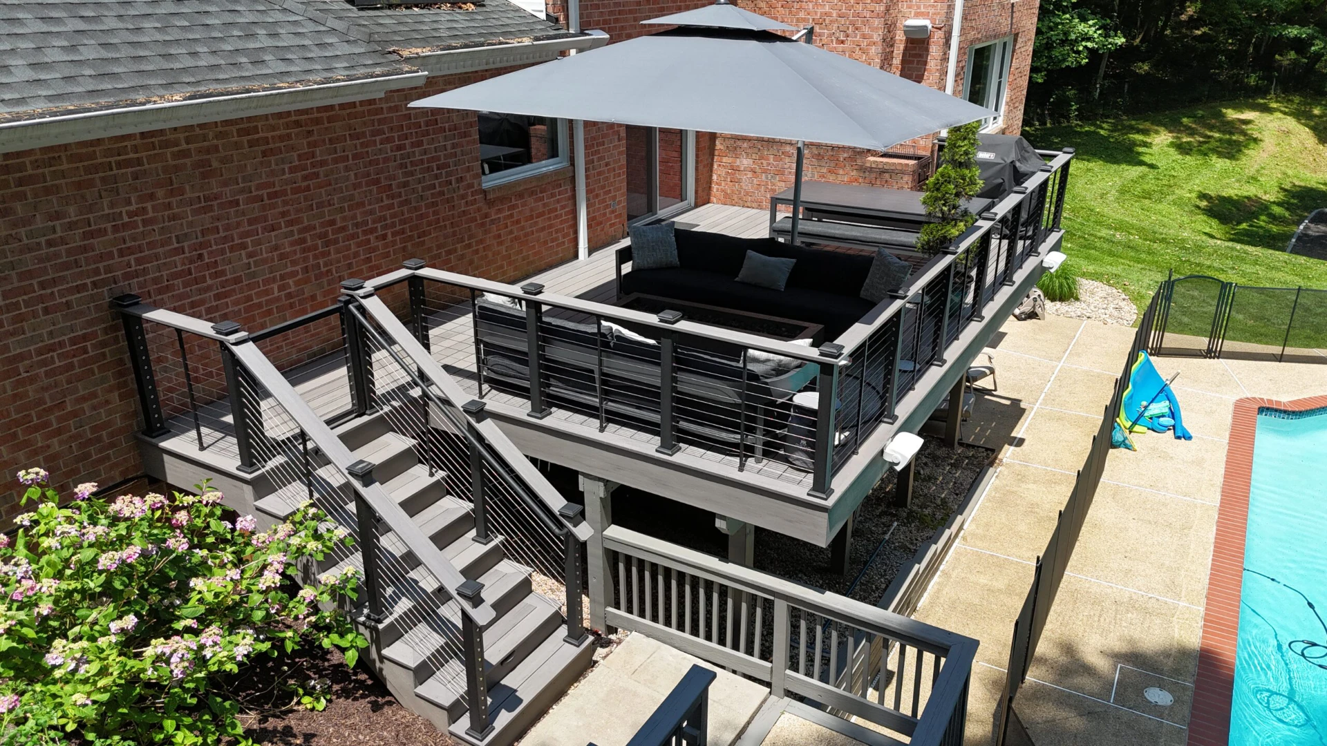 Sun kissed elevated pvc decking with furniture and privacy screen on below and a pool