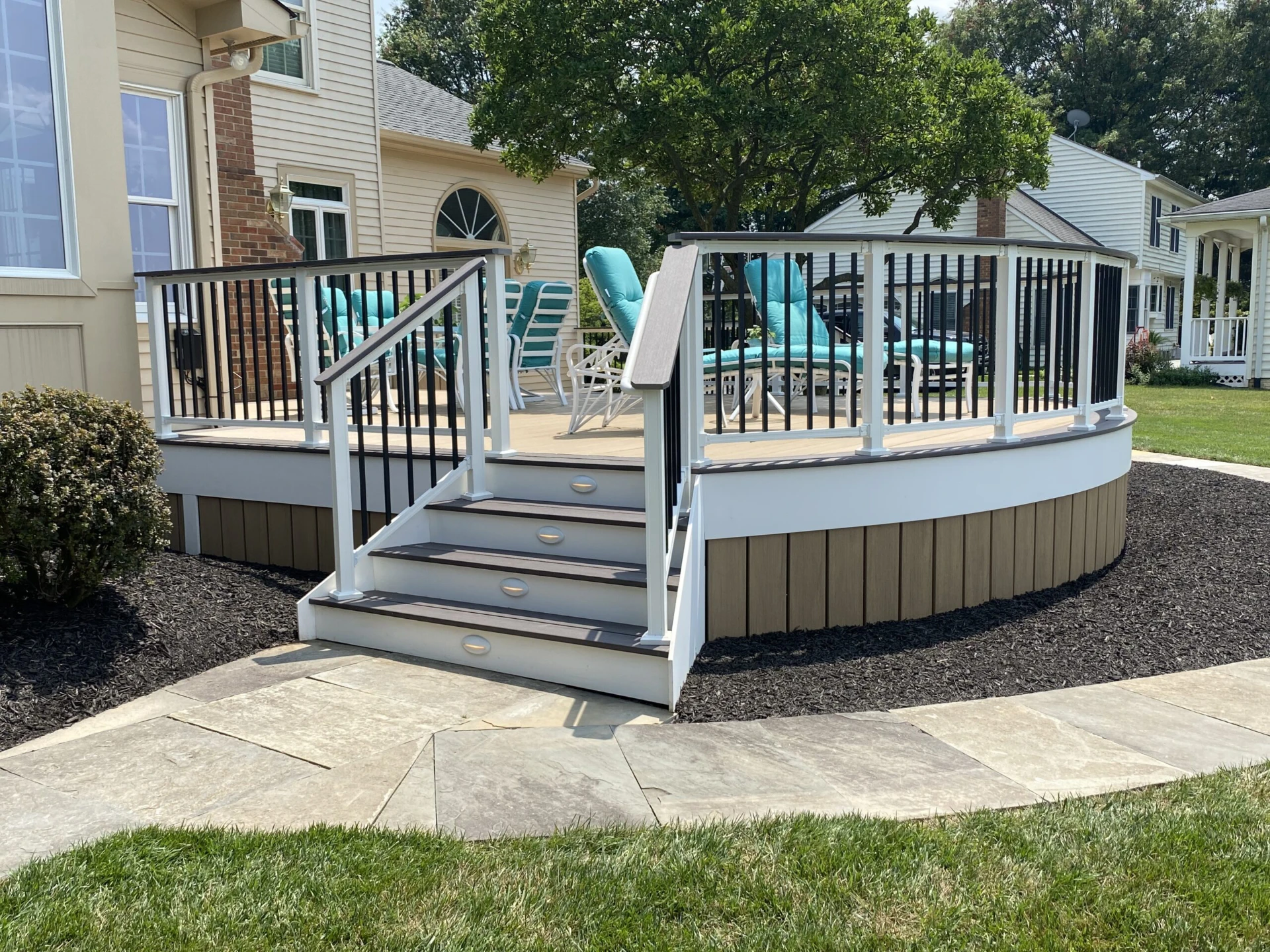 Sun kissed raised residential deck with lighting and furniture