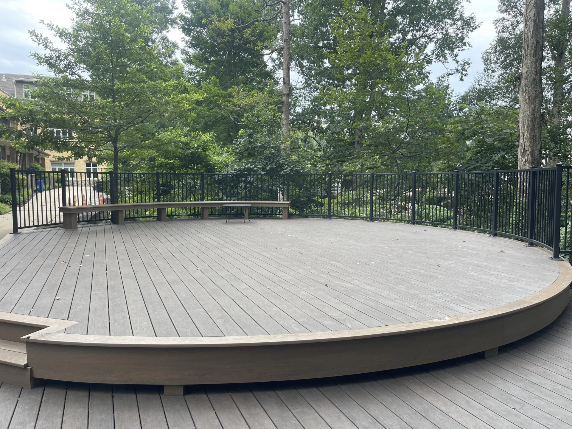 Wooden deck installation with chair and have black railing